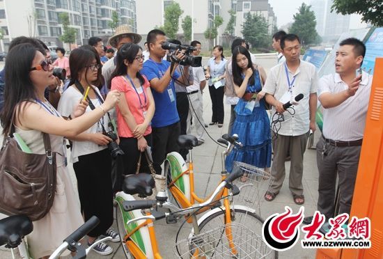 西線采訪團采訪了薛城區(qū)城市公共自行車服務系統(tǒng)，工作人員向記者們講解公共自行車的詳細情況。 記者 郭豪 攝。
